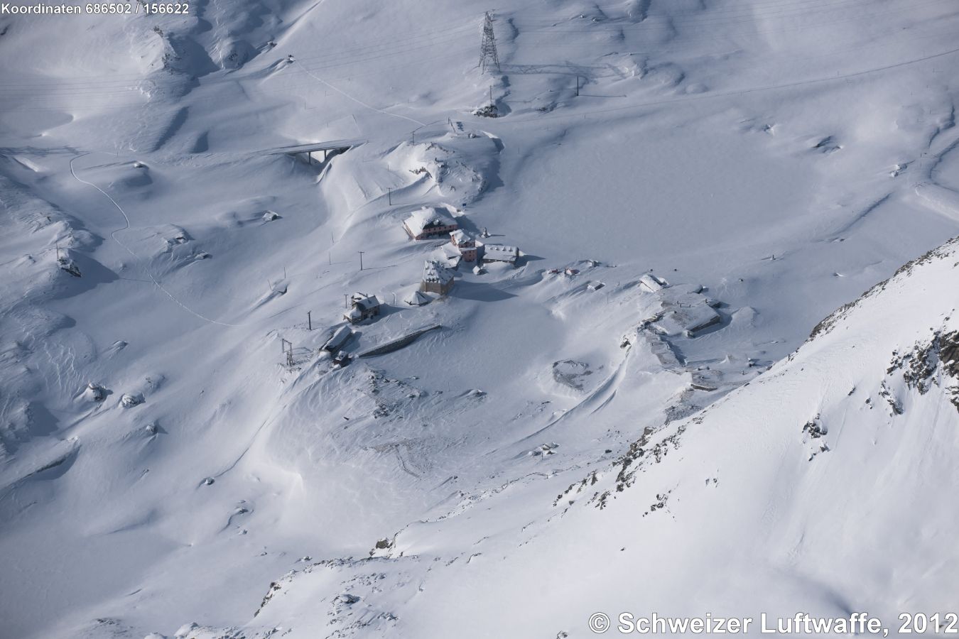 Das tief verschneite Ospizio San Gottardo, Blickrichtung W zum Piz Fibbia. Gut sichtbar der grosse Lago delle Piazza.